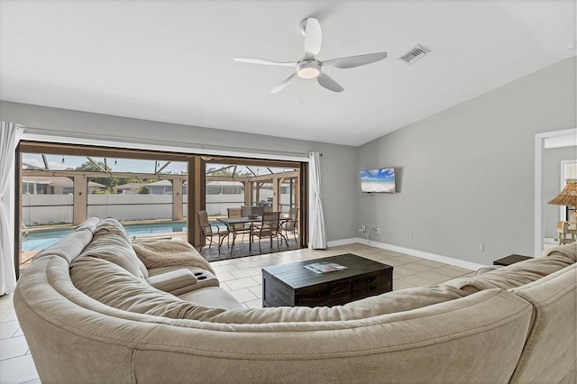 living area with visible vents, baseboards, ceiling fan, lofted ceiling, and light tile patterned floors