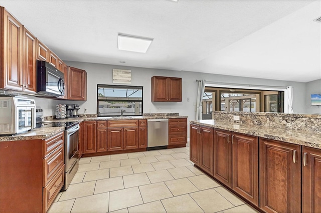 kitchen featuring a sink, light stone countertops, a wealth of natural light, and stainless steel appliances