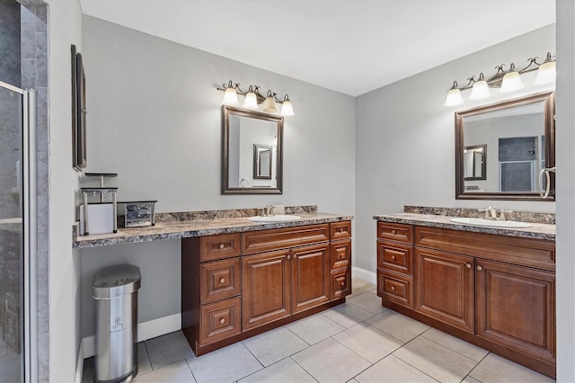 bathroom featuring tile patterned floors, a stall shower, two vanities, and a sink