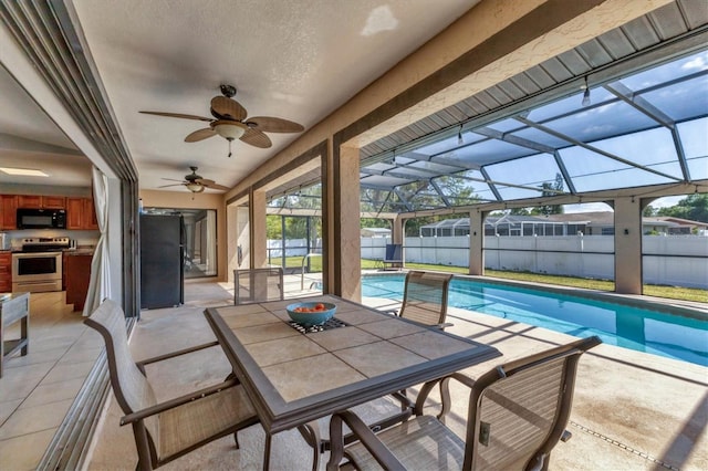 view of patio featuring glass enclosure, a fenced in pool, ceiling fan, and fence