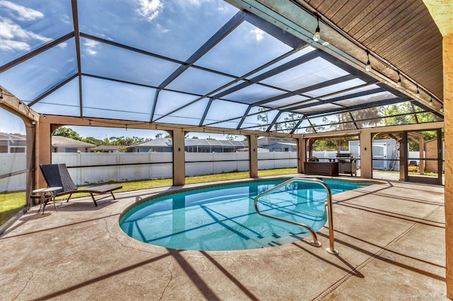 view of pool with a lanai, a patio, and a fenced backyard