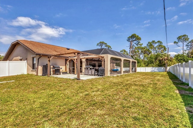 rear view of house with a patio area, a yard, a fenced backyard, and stucco siding