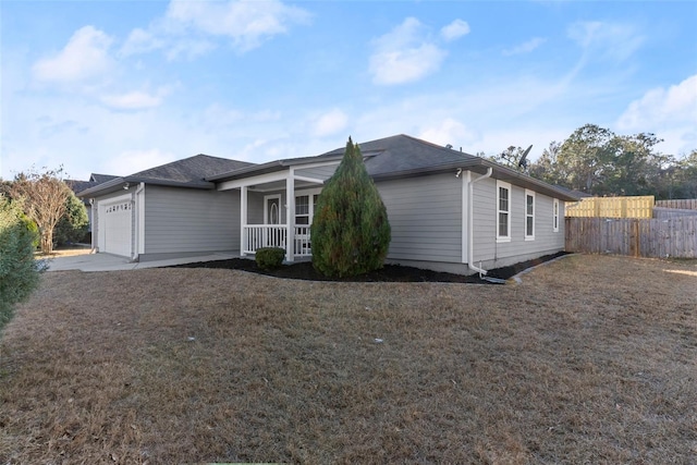 view of front of property with a garage, covered porch, and a front lawn