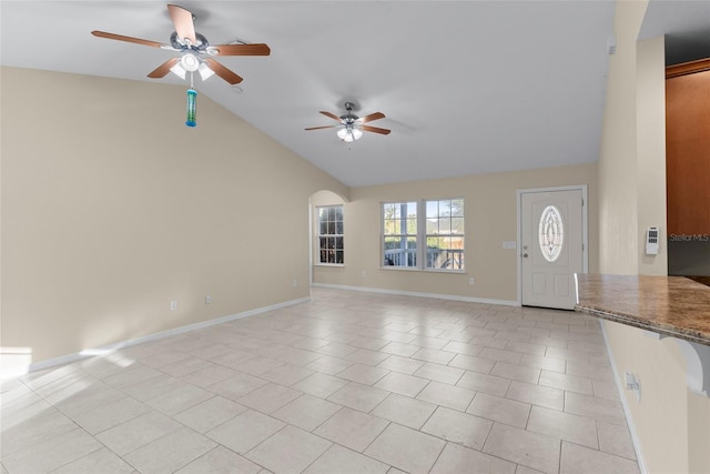 unfurnished living room with light tile patterned floors, vaulted ceiling, and ceiling fan