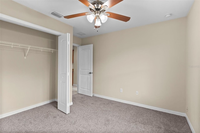 unfurnished bedroom featuring light colored carpet, a closet, and ceiling fan