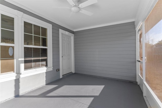 unfurnished sunroom featuring ceiling fan