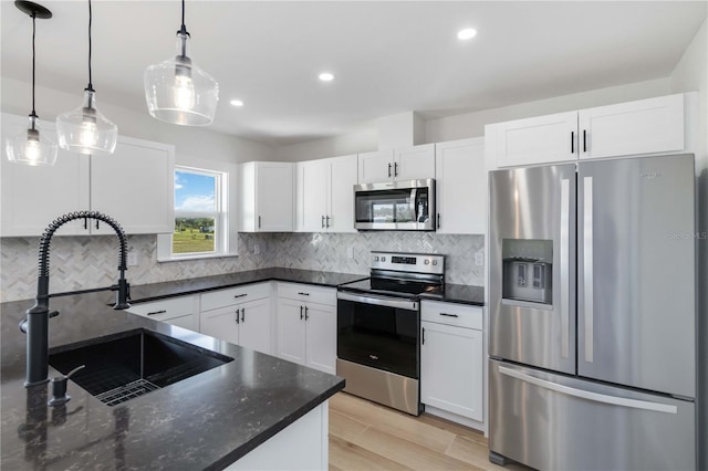 kitchen featuring sink, decorative light fixtures, white cabinets, and appliances with stainless steel finishes