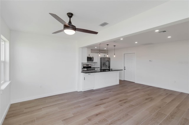 unfurnished living room featuring ceiling fan and light hardwood / wood-style floors