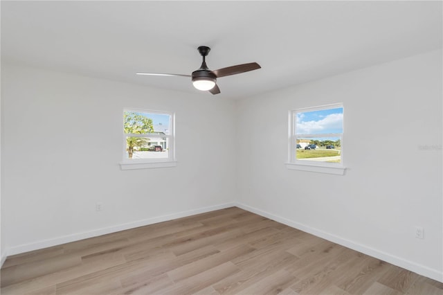 empty room with ceiling fan, a healthy amount of sunlight, and light wood-type flooring