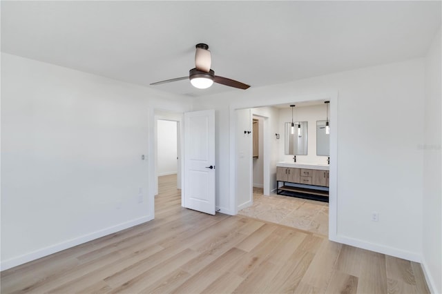 unfurnished bedroom with ceiling fan, connected bathroom, and light hardwood / wood-style flooring