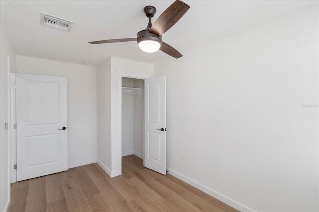 unfurnished bedroom with ceiling fan, light hardwood / wood-style floors, and a closet