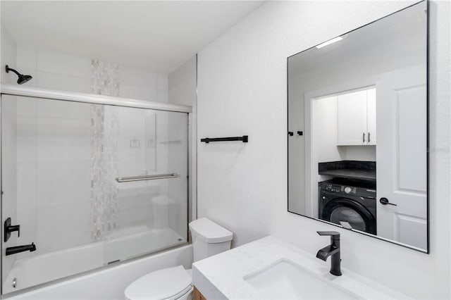 full bathroom with toilet, enclosed tub / shower combo, vanity, and washer / clothes dryer