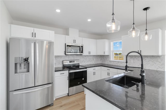 kitchen with stainless steel appliances, sink, and white cabinets