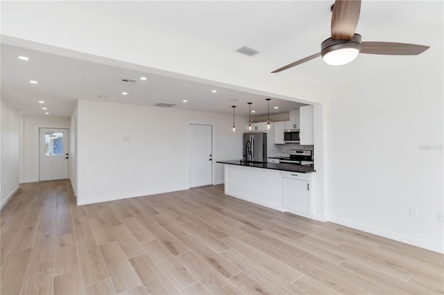 unfurnished living room featuring ceiling fan and light hardwood / wood-style floors