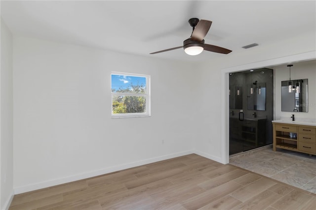 empty room with ceiling fan and light hardwood / wood-style floors