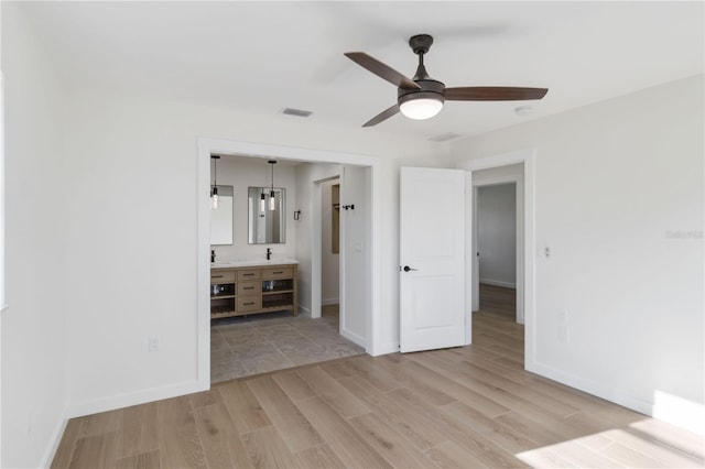 unfurnished bedroom featuring connected bathroom, light hardwood / wood-style floors, and ceiling fan