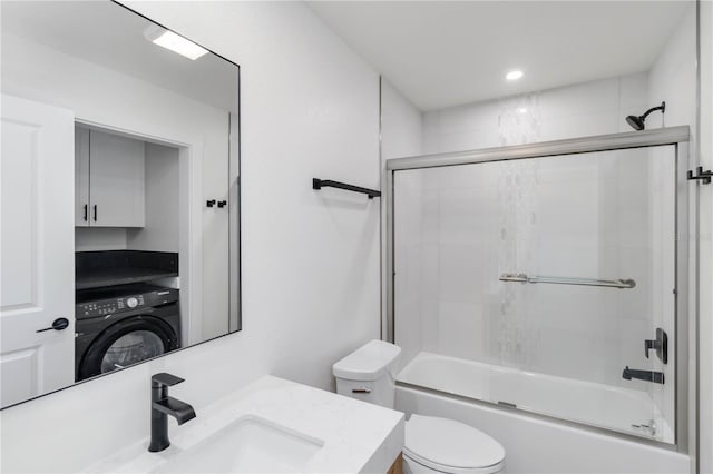 full bathroom featuring vanity, washer / dryer, combined bath / shower with glass door, and toilet