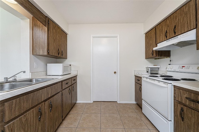 kitchen featuring white appliances, sink, and light tile patterned floors