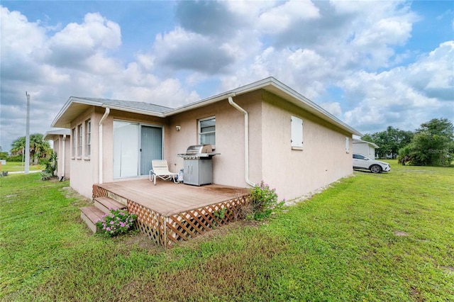 rear view of house with a lawn and a deck