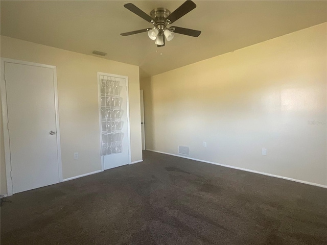 unfurnished bedroom with ceiling fan and dark colored carpet