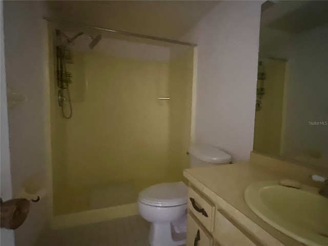 bathroom featuring vanity, toilet, and a shower