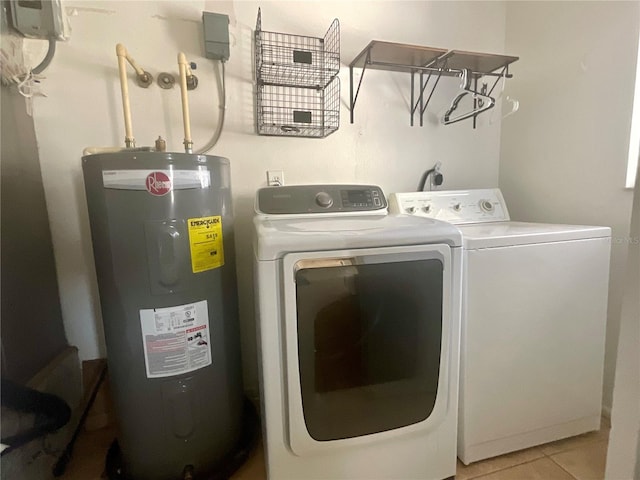 clothes washing area featuring water heater, washing machine and dryer, and light tile patterned floors