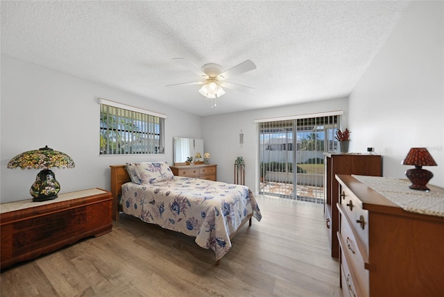 bedroom with access to exterior, light hardwood / wood-style floors, a textured ceiling, and ceiling fan