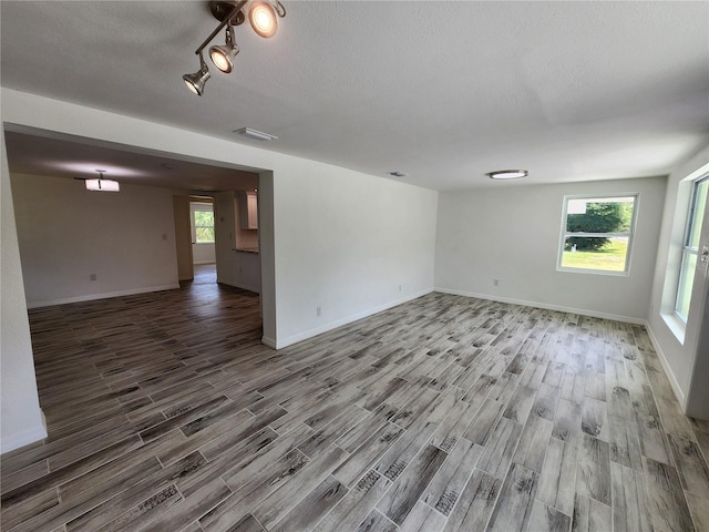 unfurnished room with wood-type flooring and a textured ceiling