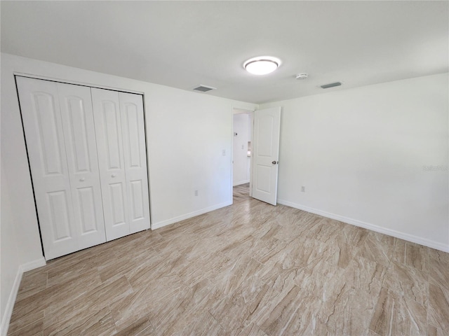 unfurnished bedroom featuring light hardwood / wood-style flooring and a closet