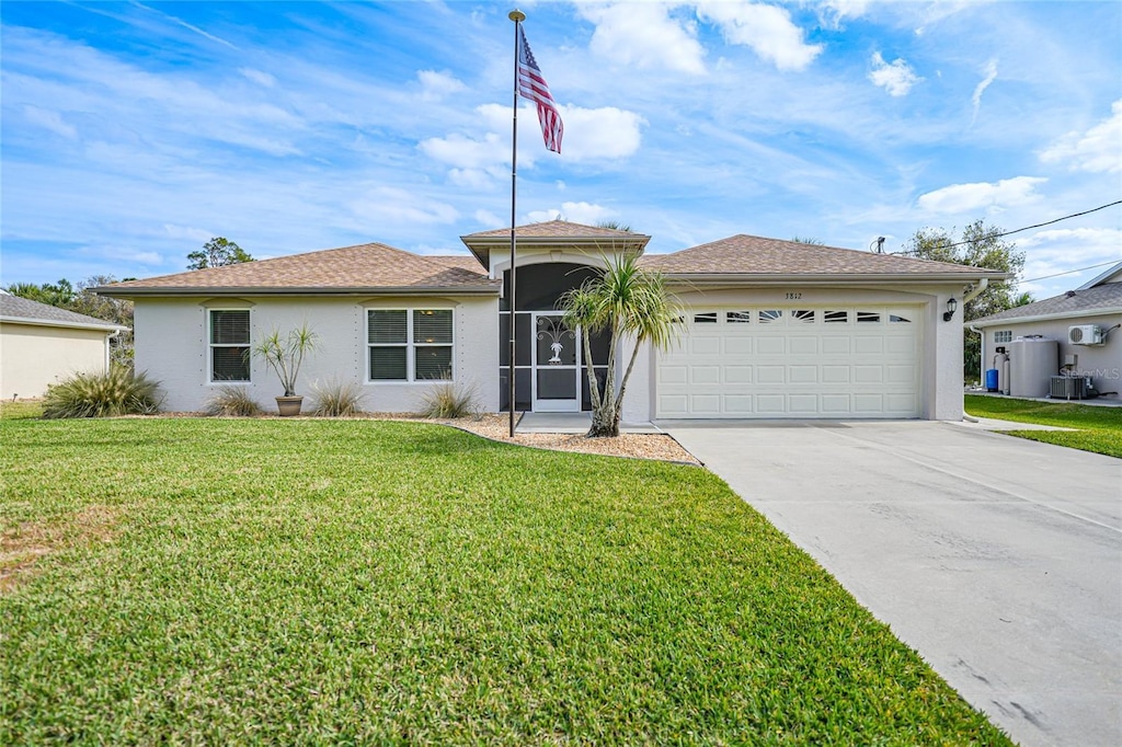 ranch-style home with a garage, a front yard, and central AC unit