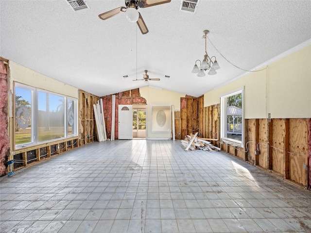 misc room with lofted ceiling, ceiling fan with notable chandelier, and a textured ceiling