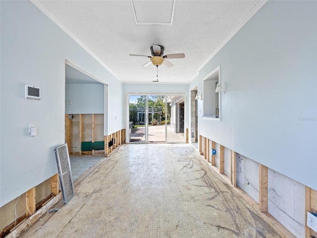 unfurnished living room with ceiling fan, ornamental molding, and a textured ceiling