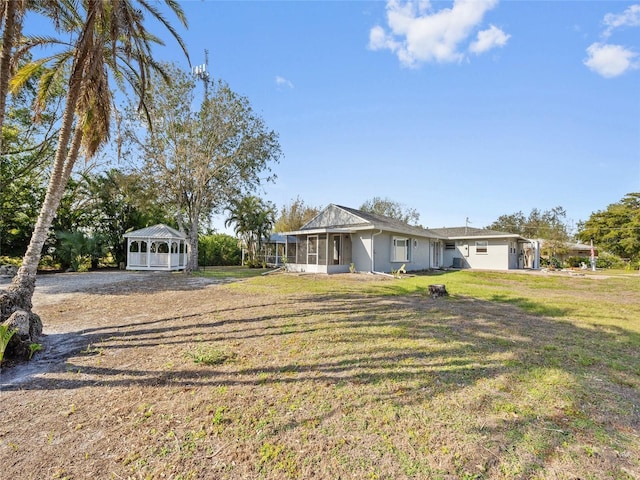 view of front of home featuring a sunroom and a front lawn