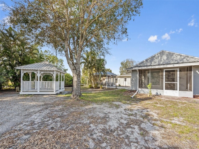 view of yard featuring a gazebo and a sunroom