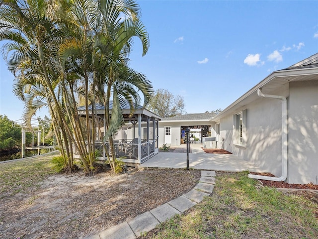 view of yard featuring a sunroom and a patio area