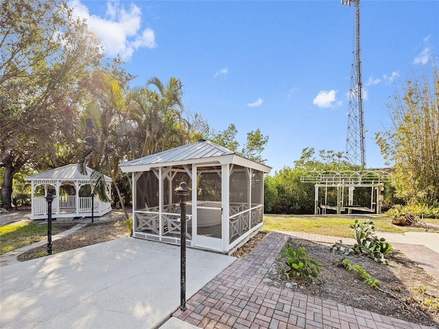 view of patio with a gazebo and a sunroom