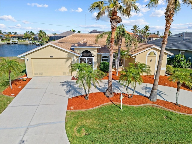 mediterranean / spanish home with a garage, a front lawn, and a water view