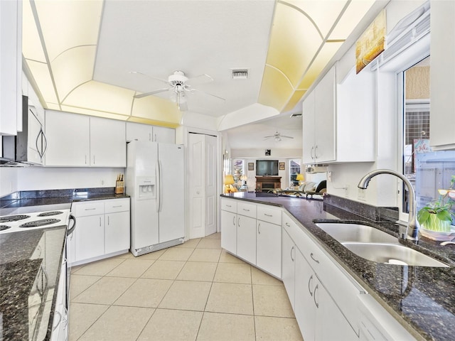 kitchen with light tile patterned flooring, sink, white cabinets, white fridge with ice dispenser, and ceiling fan