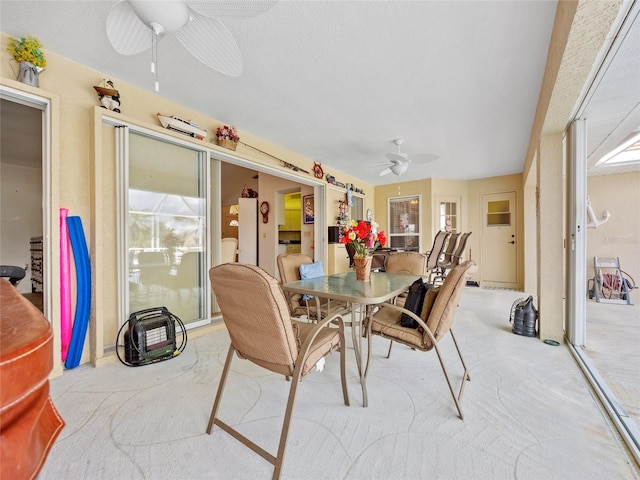 carpeted dining room with ceiling fan and a textured ceiling