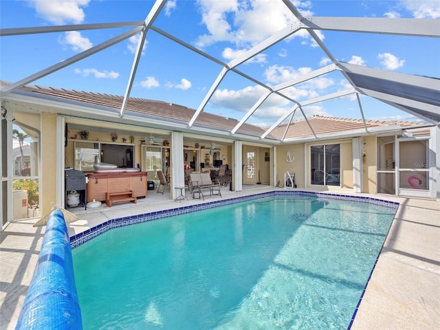 view of swimming pool featuring a lanai, a patio area, and a hot tub