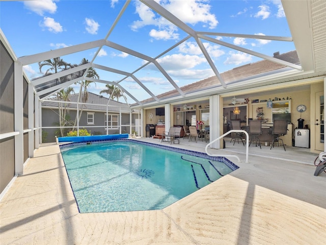 view of pool featuring a lanai, ceiling fan, and a patio area