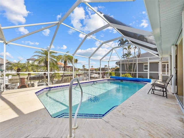 view of pool with a water view, a patio, and glass enclosure