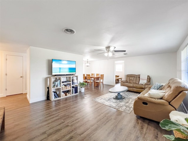 living room featuring wood-type flooring and ceiling fan