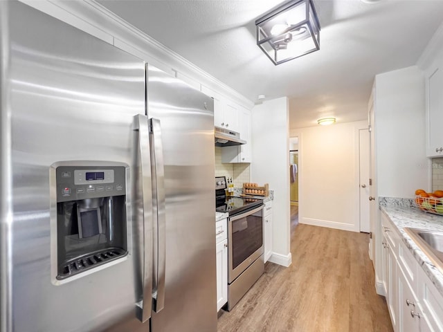 kitchen with white cabinetry, light hardwood / wood-style flooring, appliances with stainless steel finishes, light stone countertops, and decorative backsplash