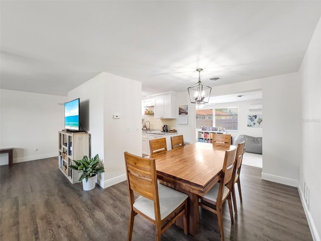 dining room with dark hardwood / wood-style flooring, sink, and a notable chandelier