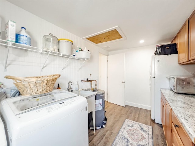 laundry area with cabinets, washer / clothes dryer, light hardwood / wood-style floors, and electric water heater