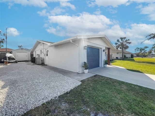 view of side of home featuring a yard, central AC unit, and a garage