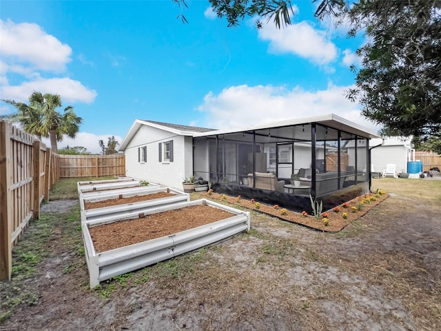 rear view of house featuring a sunroom