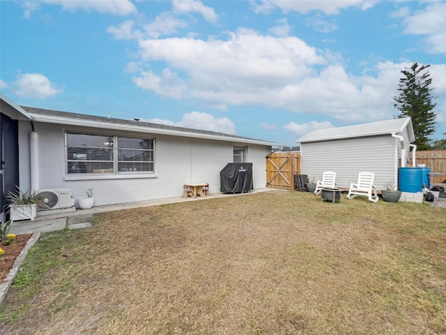 back of house with ac unit and a yard