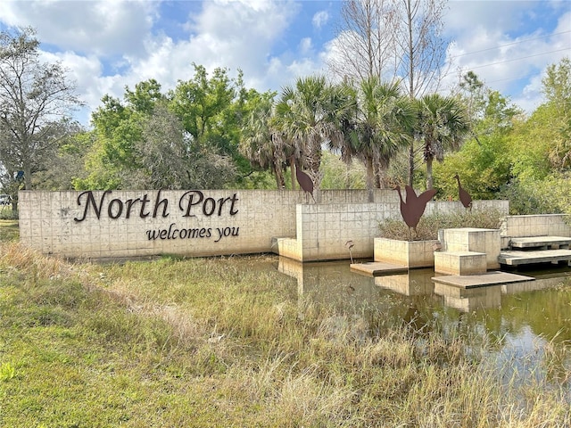 community sign featuring a water view